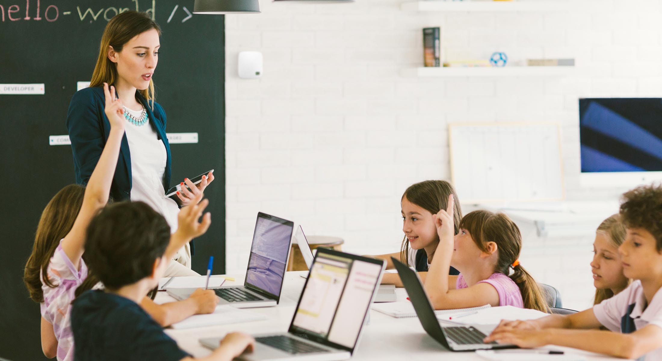 A group of children using laptops in a classroom