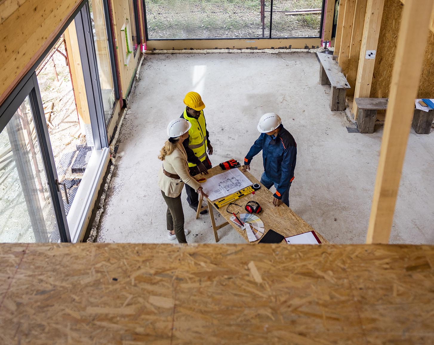 Three construction workers looking at building plans