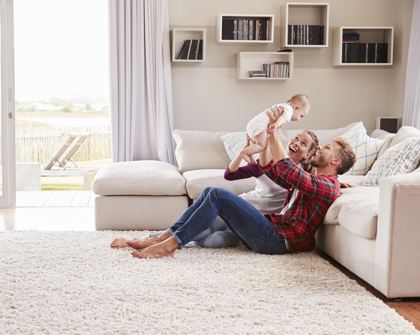 A couple holding a baby in their living room