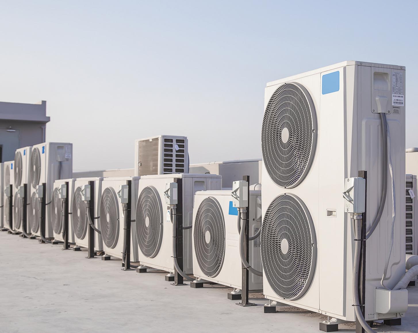 A row of HVAC units on top of a building