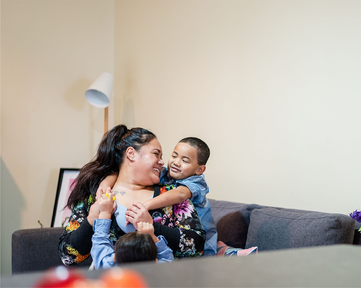 A mother plays with her two sons in their living room