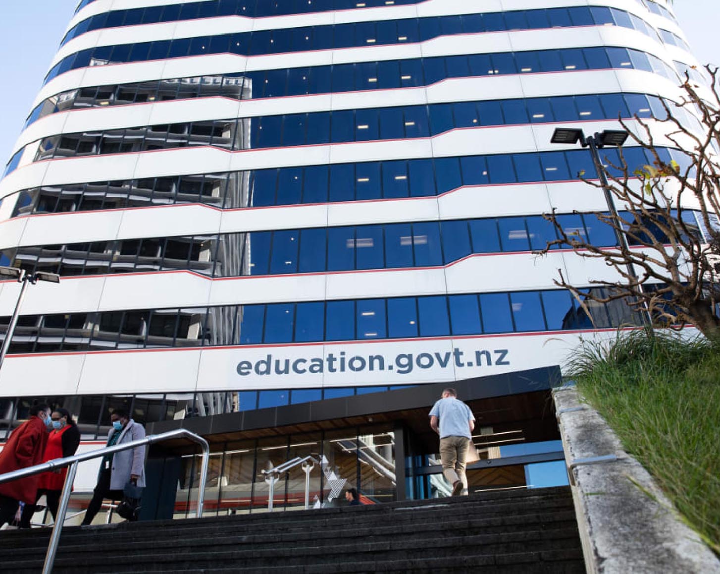 Looking up at a high-rise building labelled with the New Zealand Ministry of Education's website address