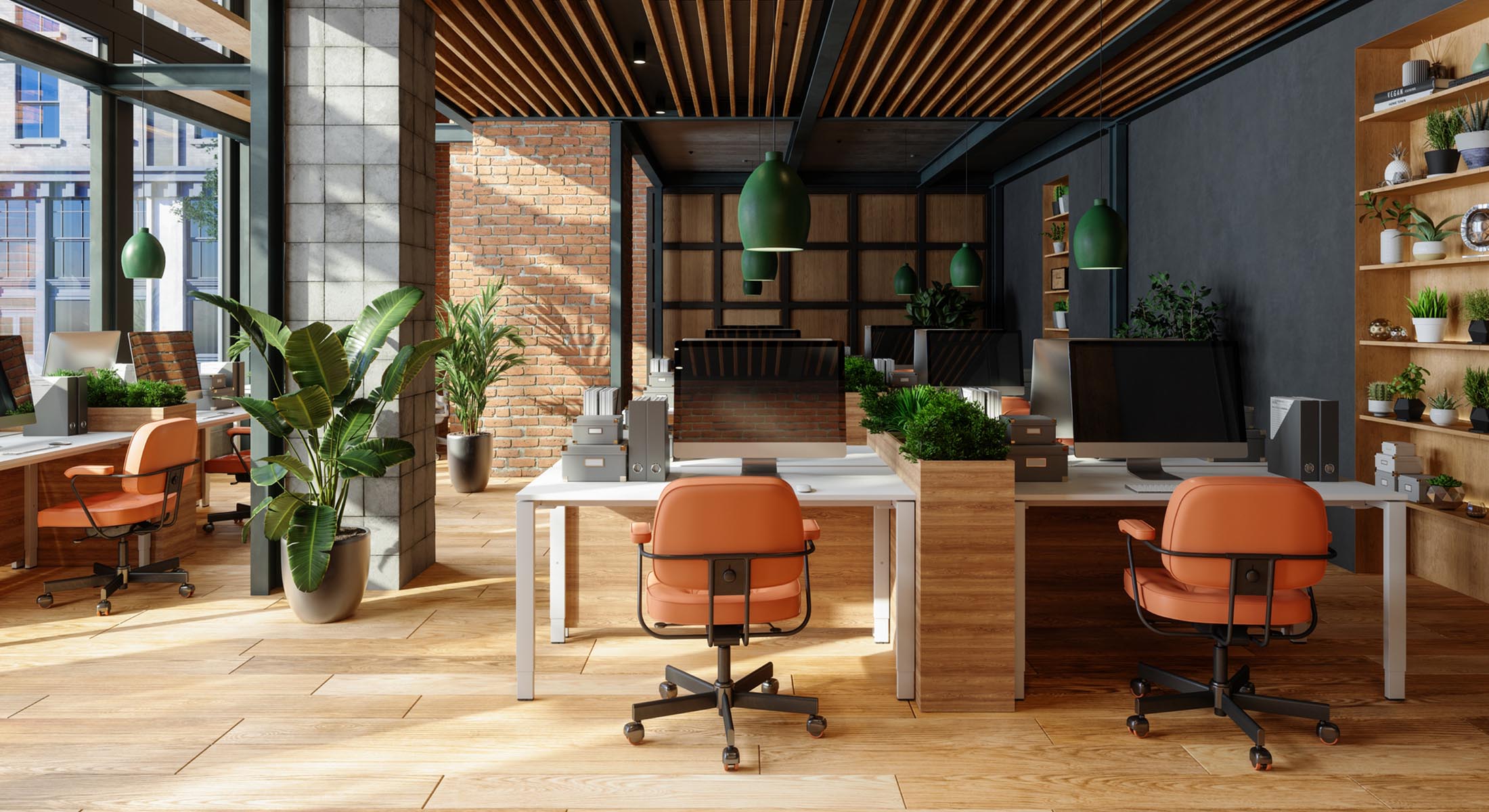 A modern office space with brick walls, plants, iMac computers and orange desk chairs