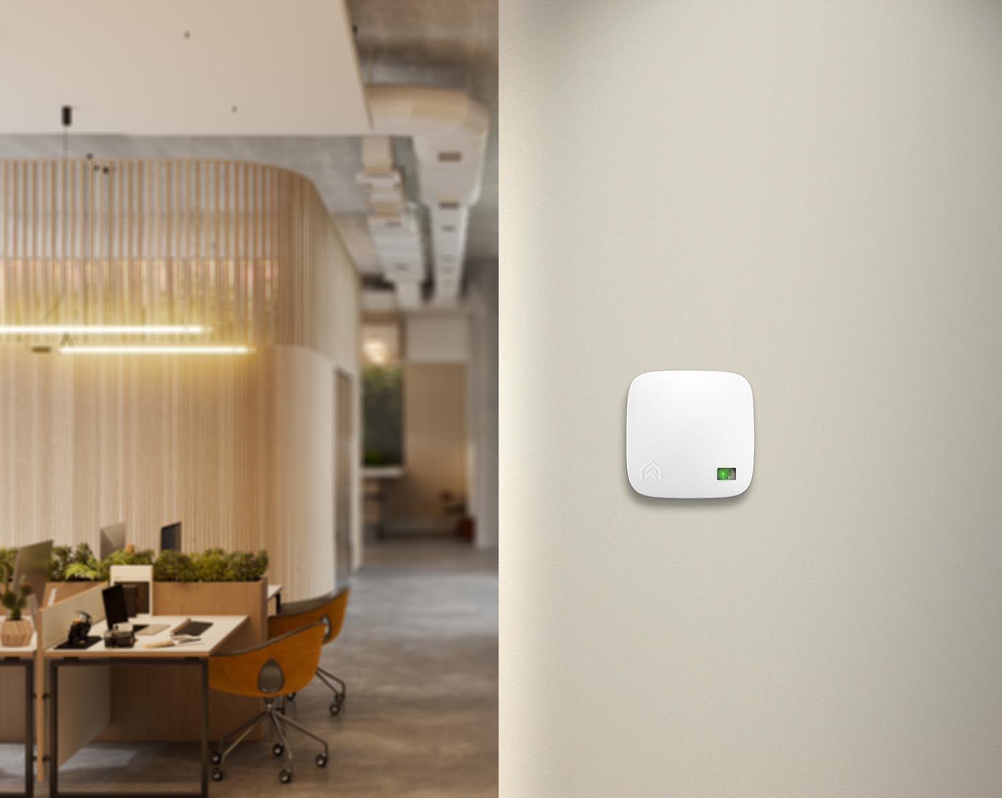 An AirSuite sensor on a wall, with office desks in the background