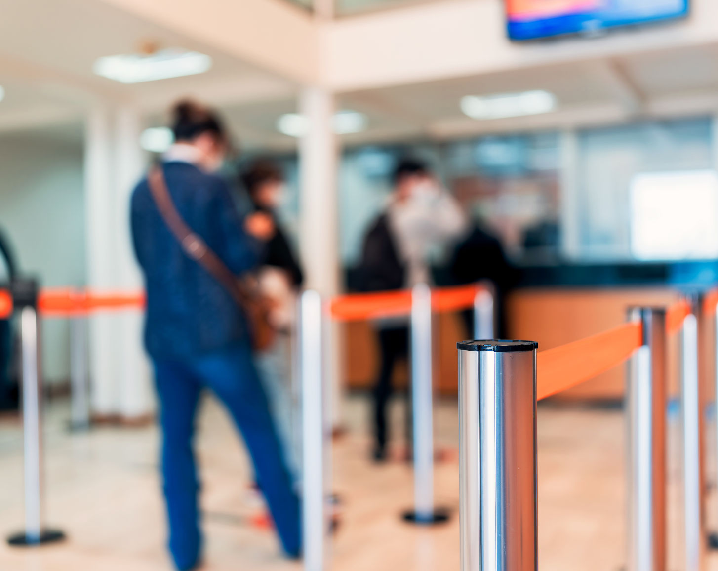 A person in a queue at a bank teller